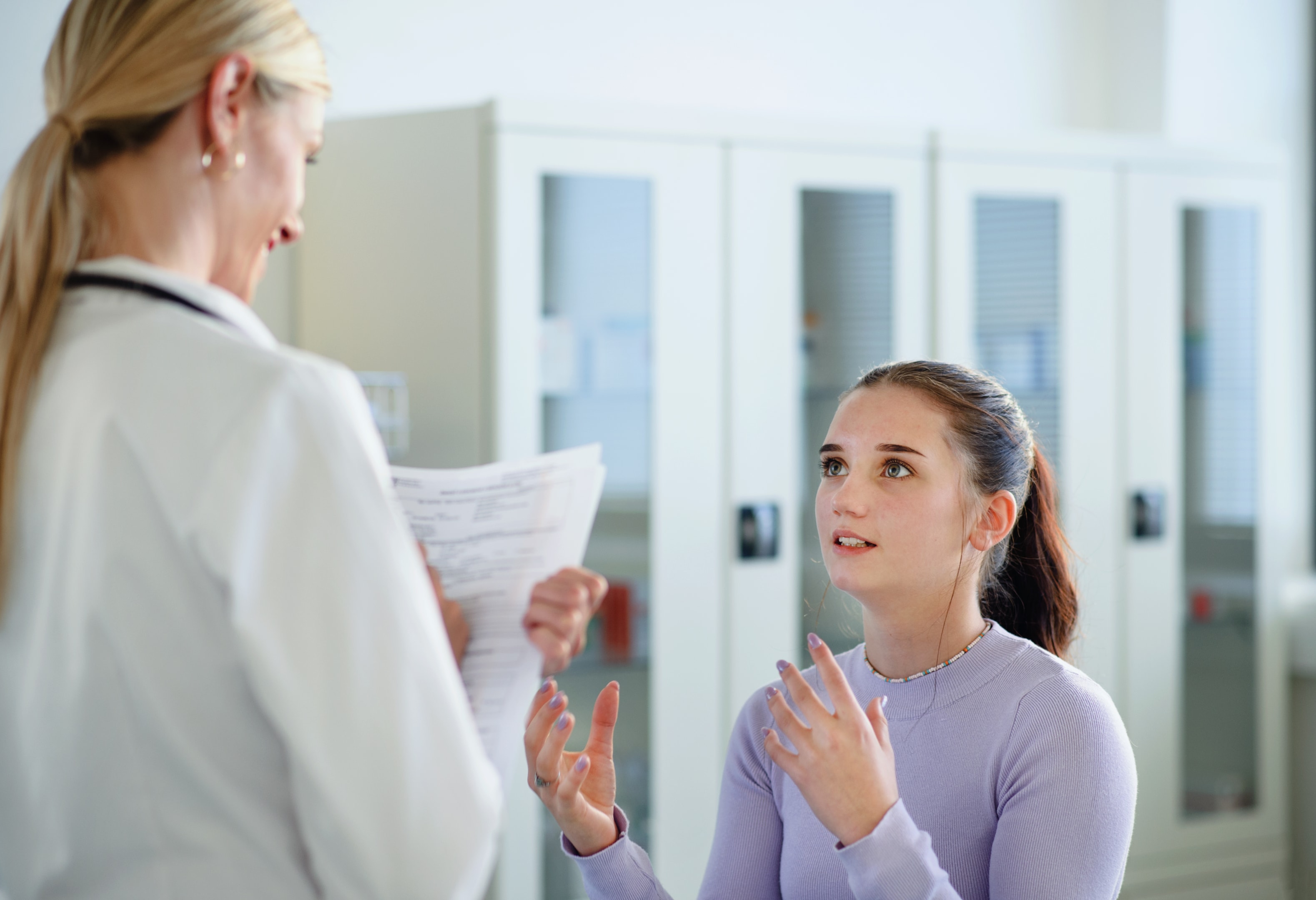 Teenager talking to oral surgeon about wisdom tooth extraction