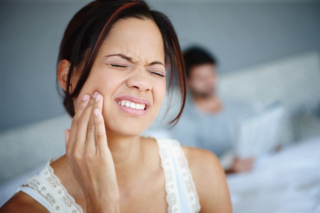 Woman with pain in teeth after wisdom tooth extraction