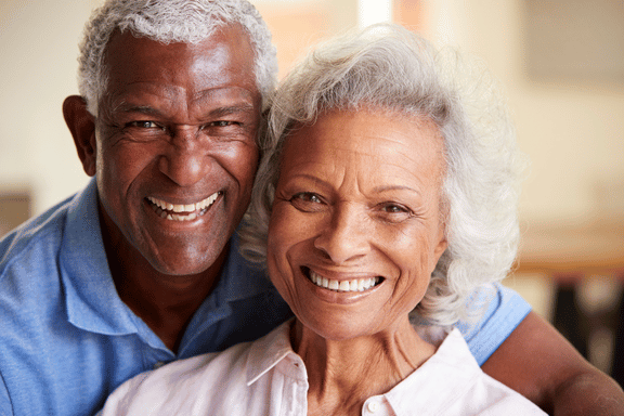 happy senior couple shows off their completed smiles after dental implants