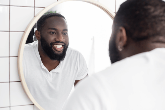 man looking in mirror at extraction site checking for any issues